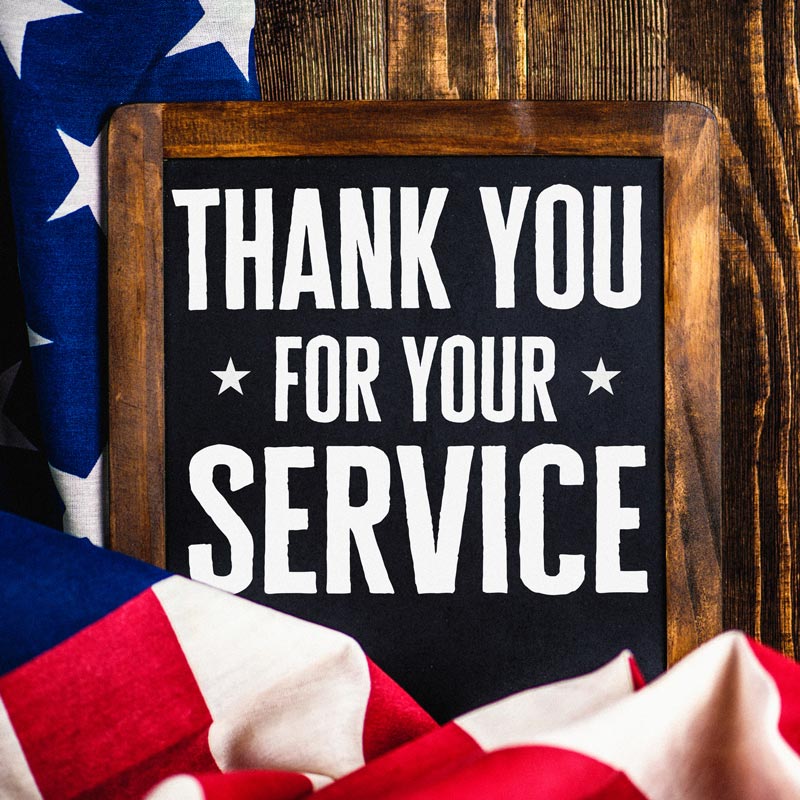 wooden chalk board that reads "thank you for your service" with a flag surrounding it.
