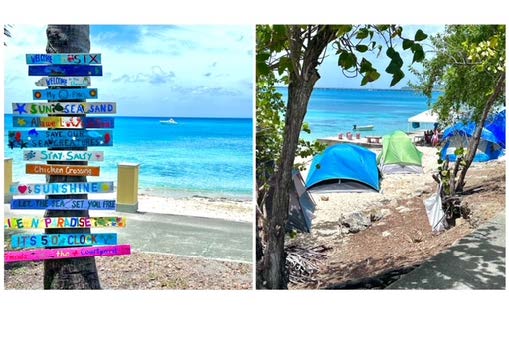 A colorful, rustic sign on a beach in St. Croix with phrases like "Sunshine" and "Sun Sea Sand".