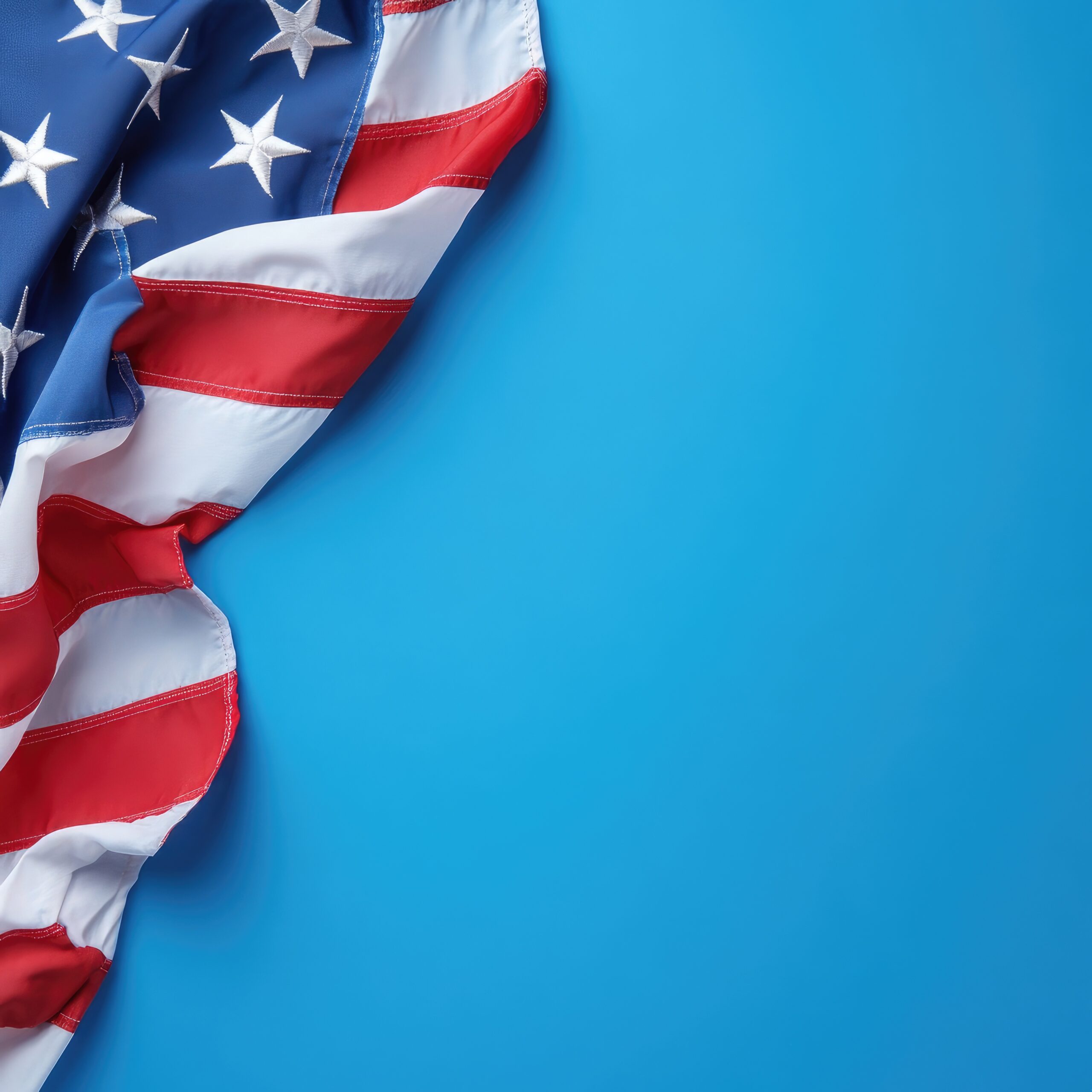 Photo of American flag on blue background, top view with copy space for text or design. USA national holiday celebration concept. Photo of American flag on dark blue background, top view with copy space for text or design. Carried out to the edge. Flat lay.